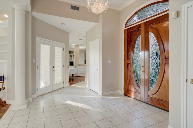 entryway featuring french doors, decorative columns, light tile patterned floors, and plenty of natural light