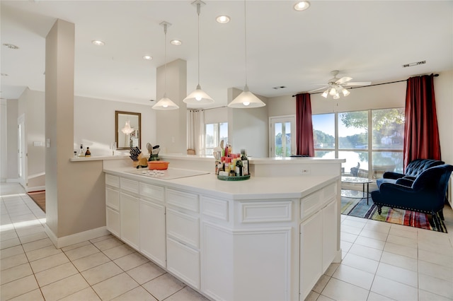 kitchen with white cabinets, light tile patterned flooring, a wealth of natural light, and hanging light fixtures