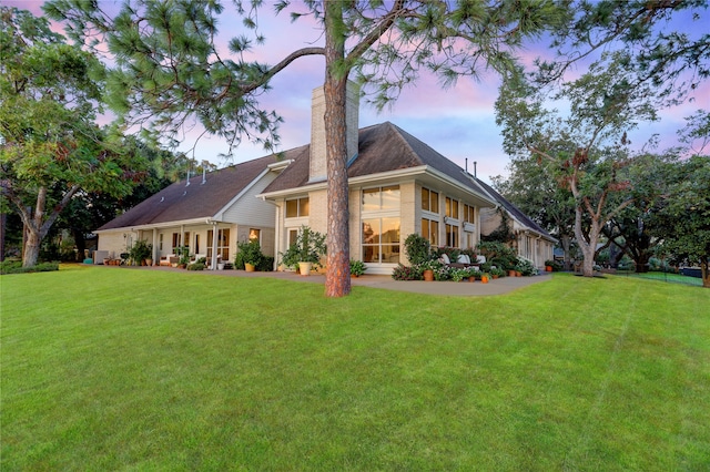 back house at dusk with a yard