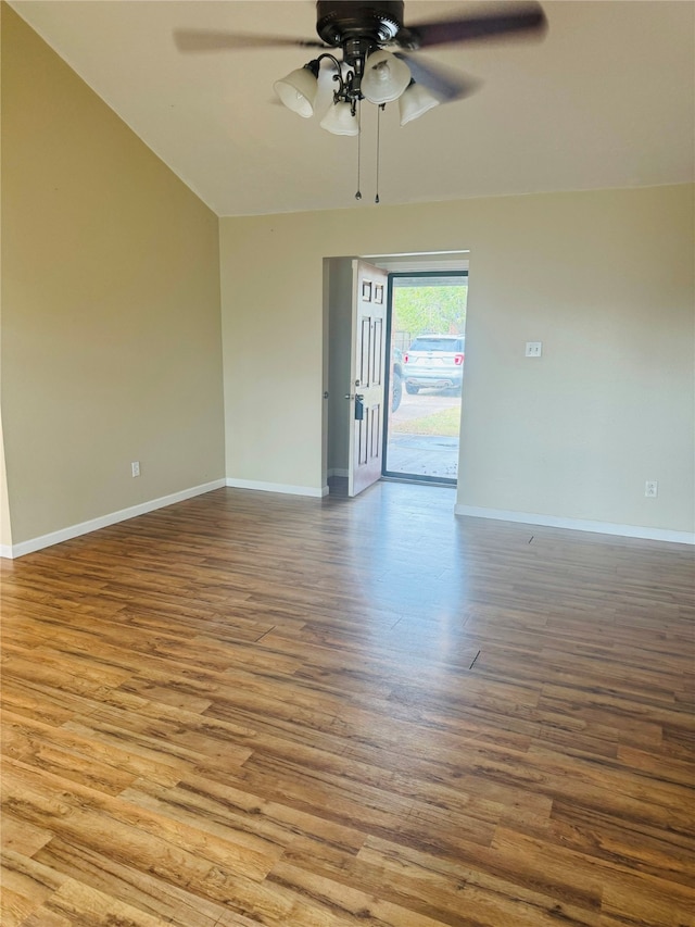 empty room featuring ceiling fan, vaulted ceiling, and hardwood / wood-style flooring