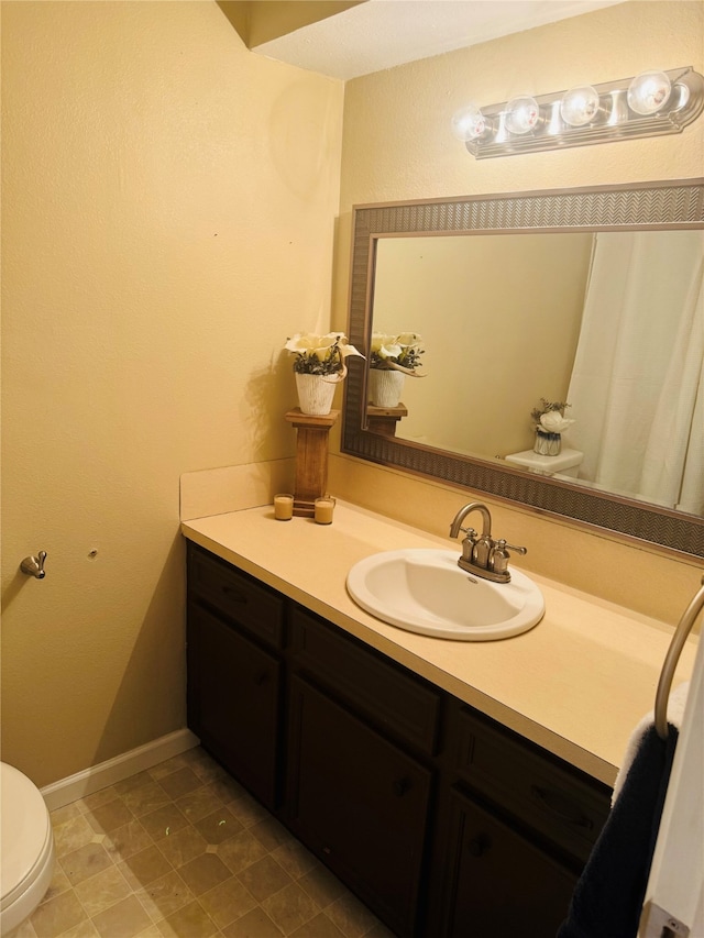 bathroom with tile patterned floors, vanity, and toilet