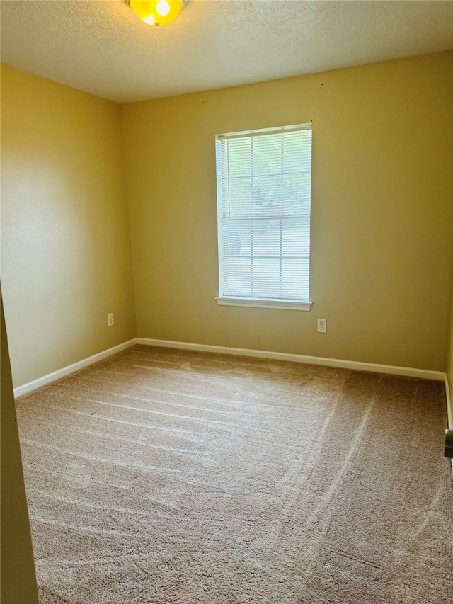 carpeted spare room featuring a textured ceiling