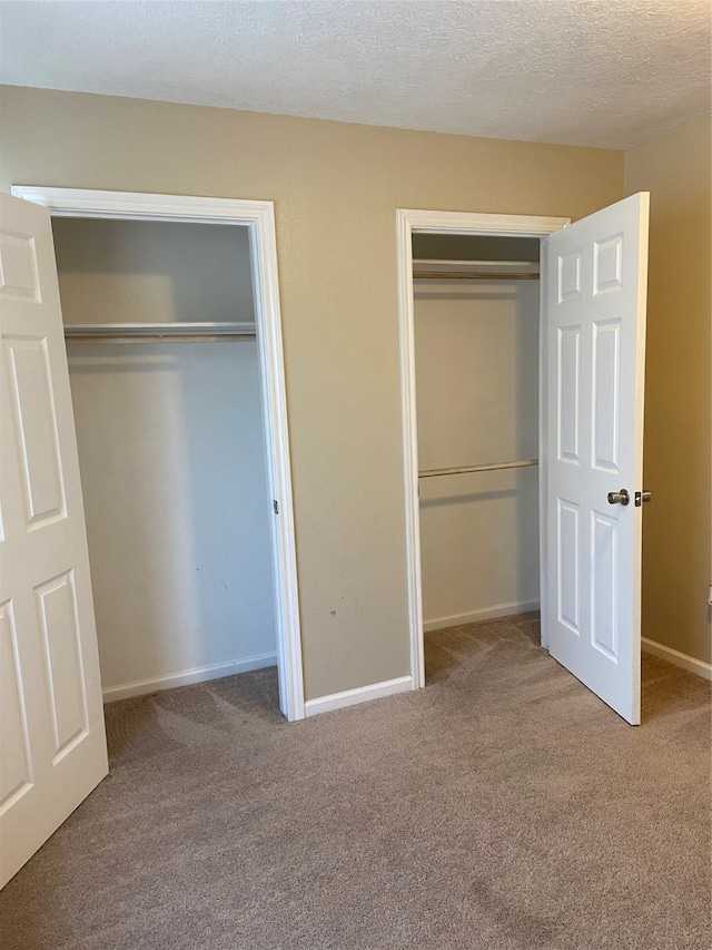 unfurnished bedroom featuring a textured ceiling and light colored carpet