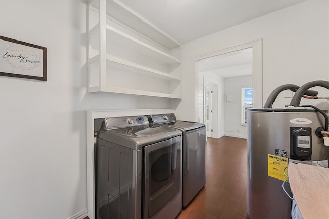 clothes washing area featuring washer and clothes dryer, electric water heater, and dark hardwood / wood-style floors