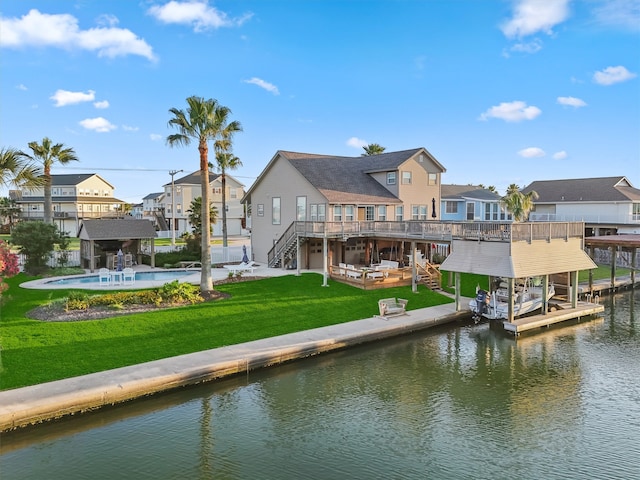 rear view of property featuring a lawn and a pool side deck with water view