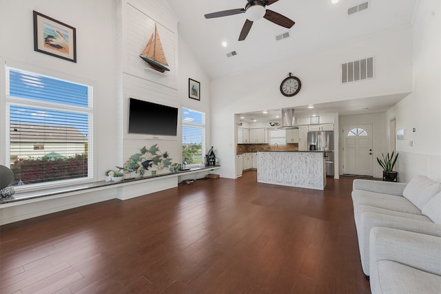 living room featuring a healthy amount of sunlight, high vaulted ceiling, dark wood-type flooring, and ceiling fan