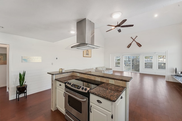 kitchen featuring lofted ceiling, dark stone counters, white cabinets, stainless steel electric range oven, and exhaust hood