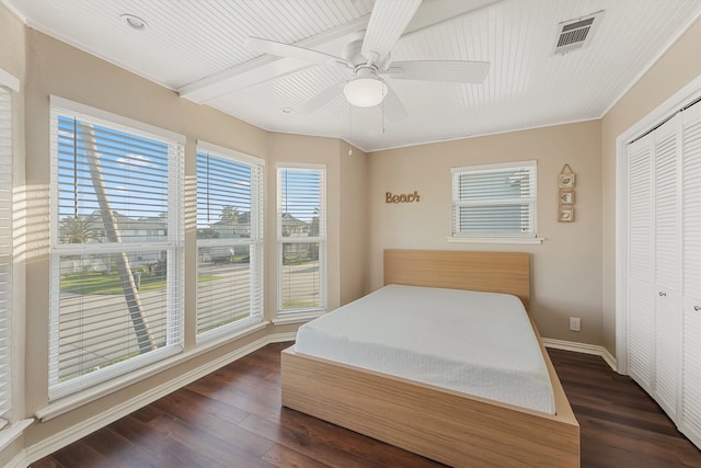 bedroom featuring a closet, dark hardwood / wood-style floors, crown molding, and ceiling fan