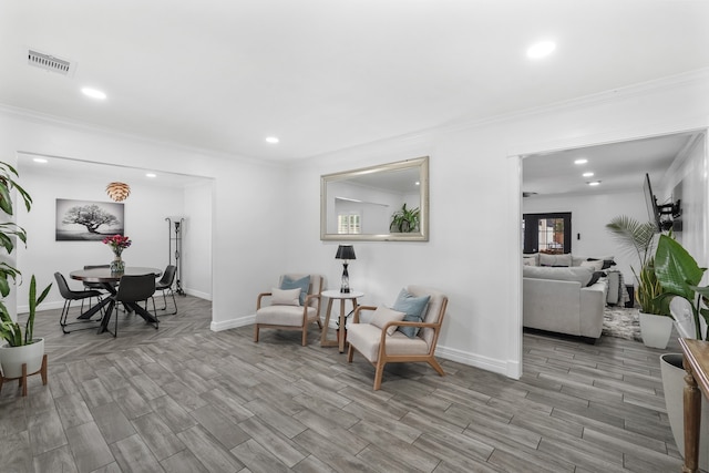 sitting room featuring light hardwood / wood-style floors and crown molding