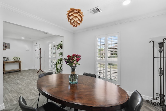 dining area featuring light hardwood / wood-style floors and ornamental molding