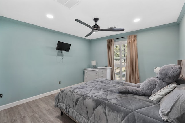 bedroom featuring ornamental molding, light hardwood / wood-style floors, and ceiling fan