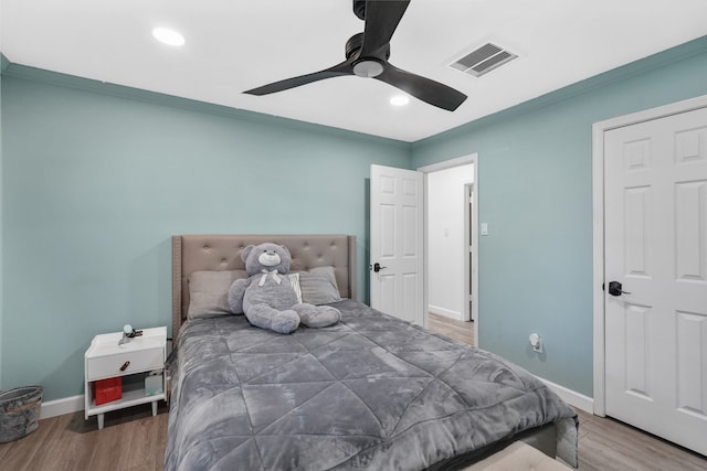 bedroom featuring ornamental molding, wood-type flooring, and ceiling fan