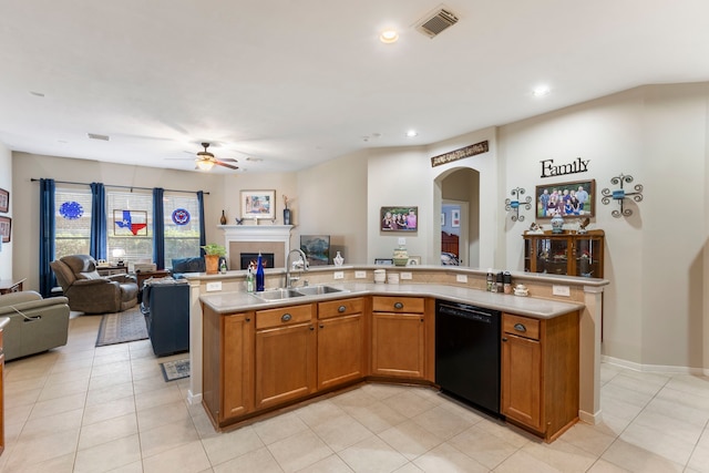 kitchen featuring black dishwasher, an island with sink, sink, light tile patterned floors, and ceiling fan