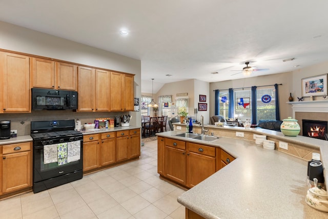 kitchen with sink, black appliances, pendant lighting, a fireplace, and ceiling fan