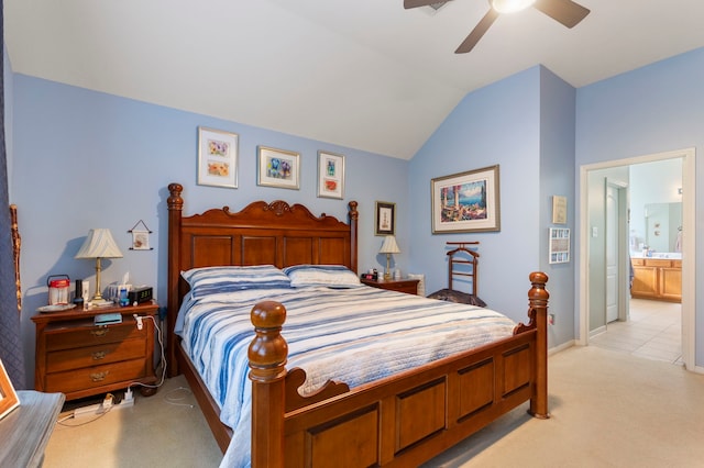 bedroom featuring light carpet, ensuite bathroom, vaulted ceiling, and ceiling fan