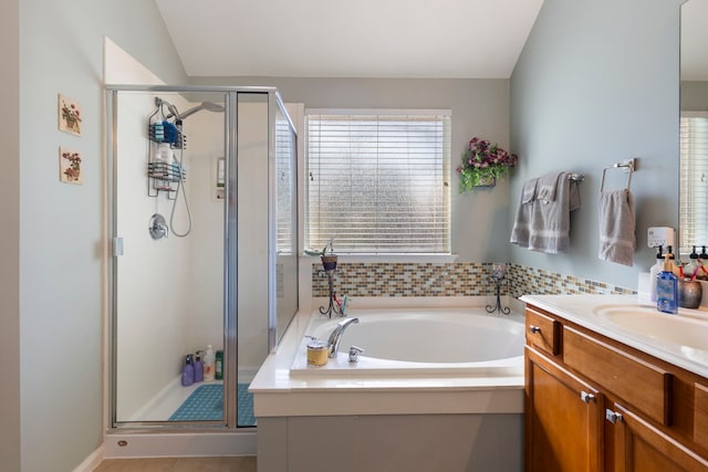 bathroom with vanity, tile patterned flooring, separate shower and tub, and vaulted ceiling