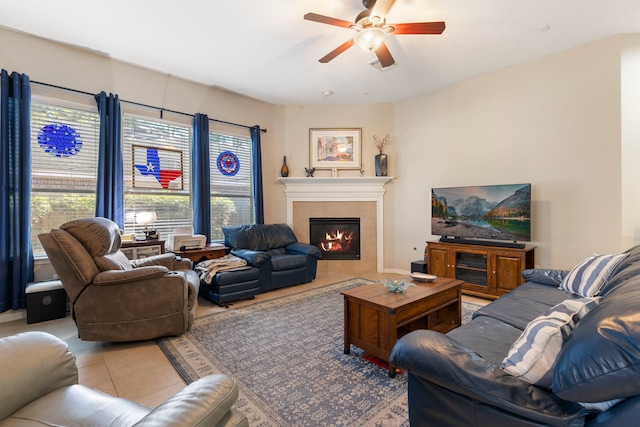 tiled living room featuring a fireplace and ceiling fan