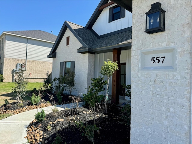 entrance to property featuring a shingled roof and board and batten siding