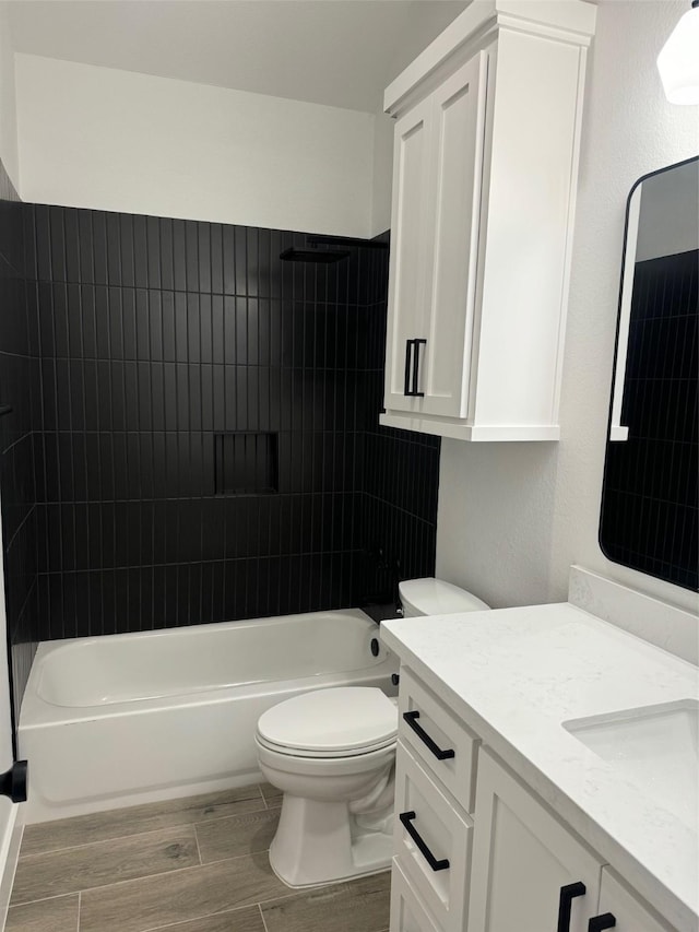 bathroom featuring toilet, vanity,  shower combination, and wood finish floors