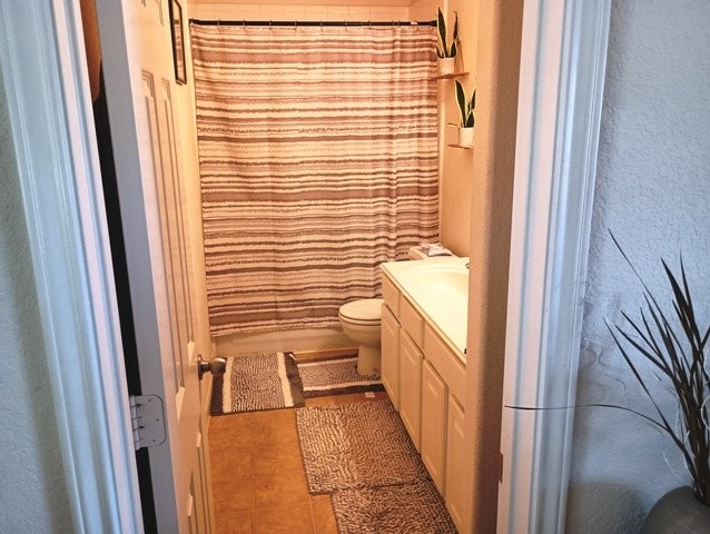 bathroom featuring vanity, a shower with curtain, toilet, and tile patterned flooring