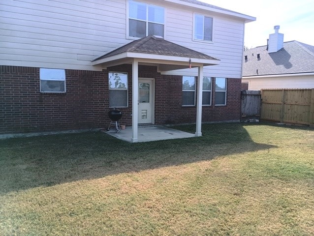 back of house featuring a patio area and a lawn