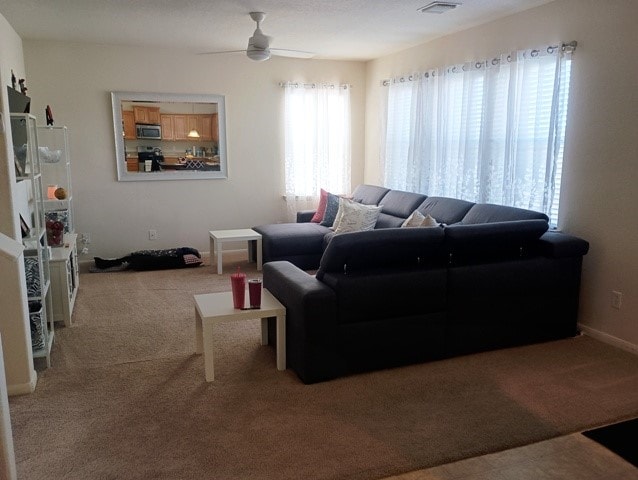 carpeted living room featuring ceiling fan