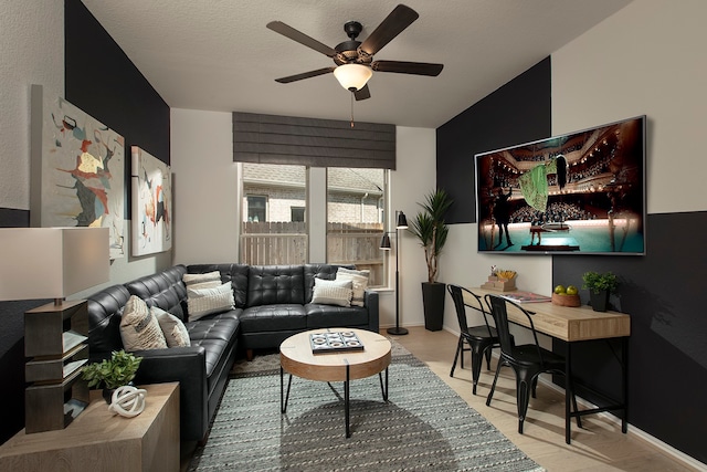 living room with ceiling fan, a textured ceiling, vaulted ceiling, and light wood-type flooring