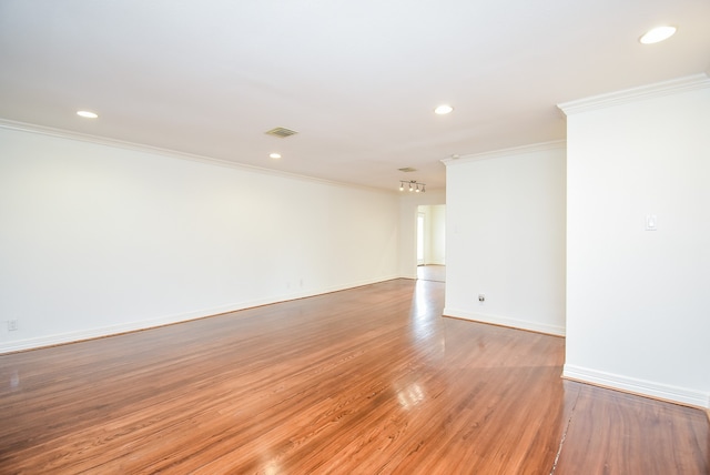 spare room with light hardwood / wood-style floors and crown molding