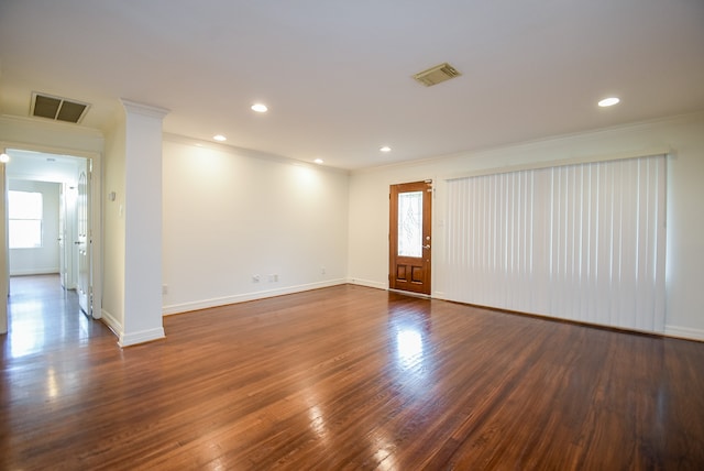 empty room featuring crown molding and dark hardwood / wood-style floors