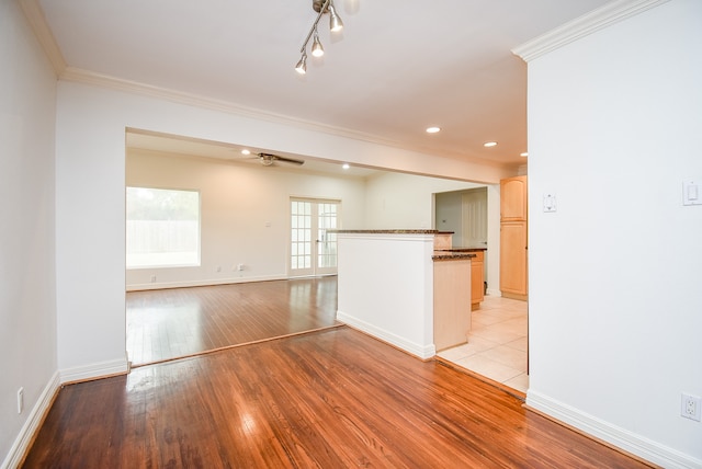 unfurnished room with french doors, ceiling fan, ornamental molding, and light wood-type flooring