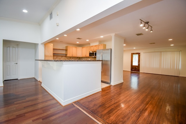 kitchen with light brown cabinetry, kitchen peninsula, stainless steel appliances, crown molding, and dark hardwood / wood-style floors