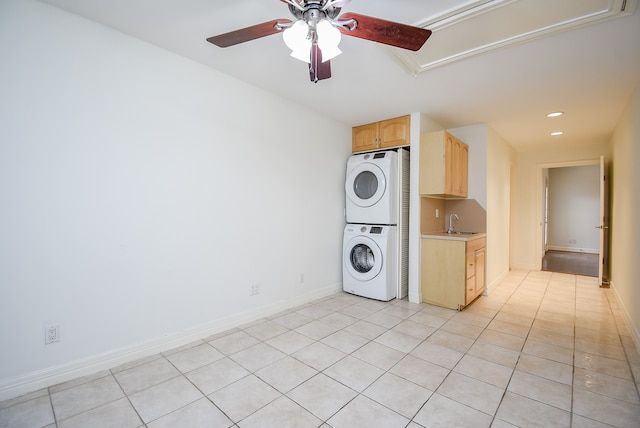 laundry room featuring stacked washer / drying machine, sink, light tile patterned floors, and ceiling fan