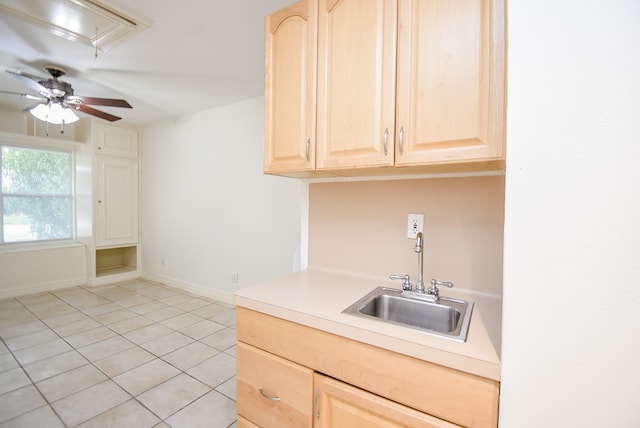 kitchen with light tile patterned flooring, light brown cabinets, sink, and ceiling fan