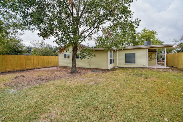 back of house featuring a patio area, central AC, and a yard