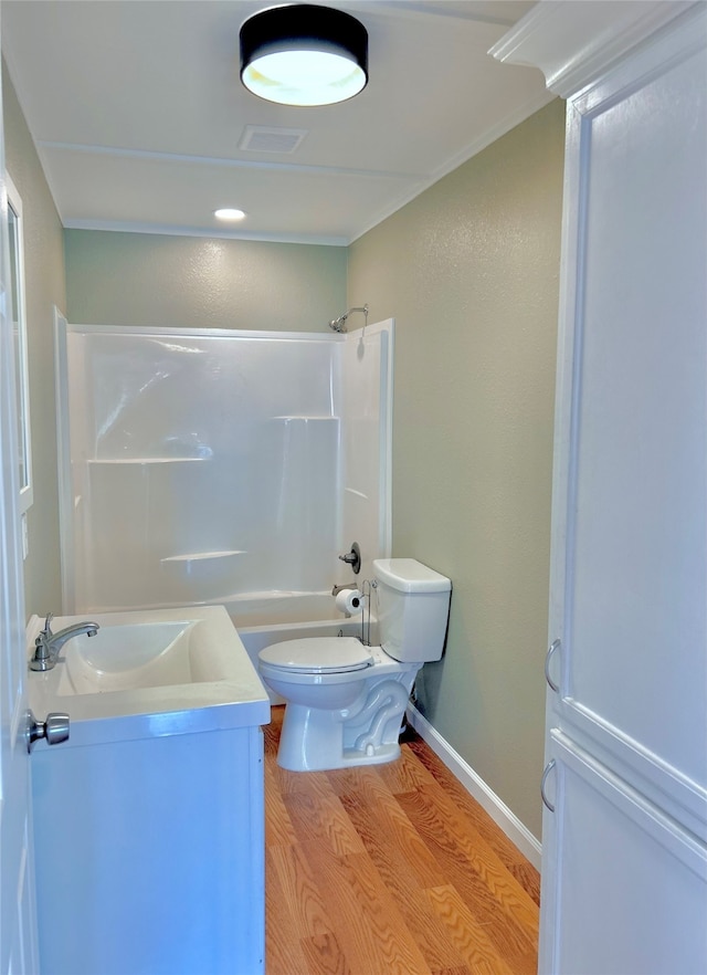 full bathroom with wood-type flooring, toilet, vanity, ornamental molding, and tub / shower combination