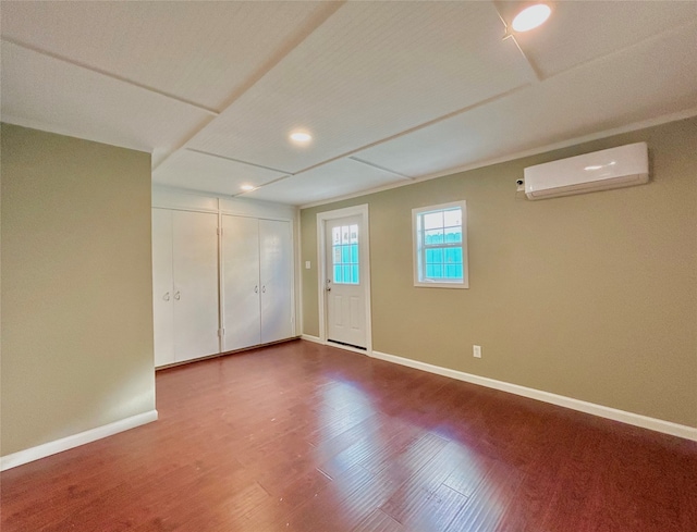 interior space with a wall mounted air conditioner and hardwood / wood-style flooring