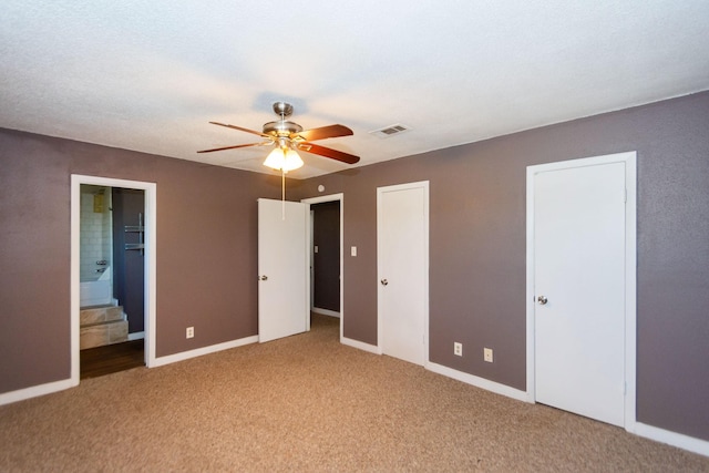 unfurnished bedroom featuring connected bathroom, ceiling fan, and light colored carpet