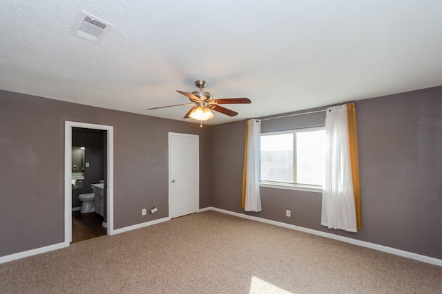 unfurnished bedroom with carpet flooring, connected bathroom, and ceiling fan