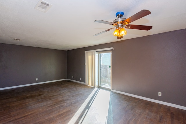 spare room featuring ceiling fan and dark wood-type flooring