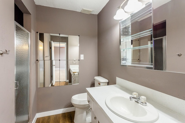 bathroom with toilet, vanity, a textured ceiling, and hardwood / wood-style flooring