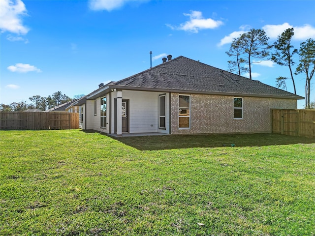 rear view of property featuring a lawn and a patio