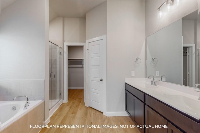 bathroom with lofted ceiling, vanity, wood-type flooring, and shower with separate bathtub