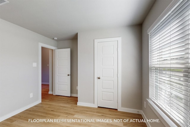 unfurnished bedroom with light wood-type flooring and multiple windows