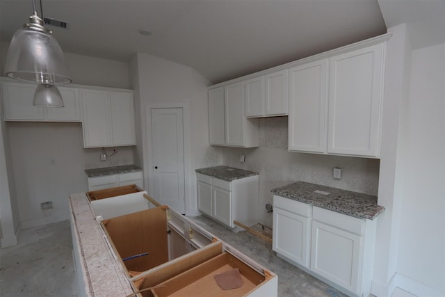 kitchen featuring decorative light fixtures, white cabinets, and a kitchen island