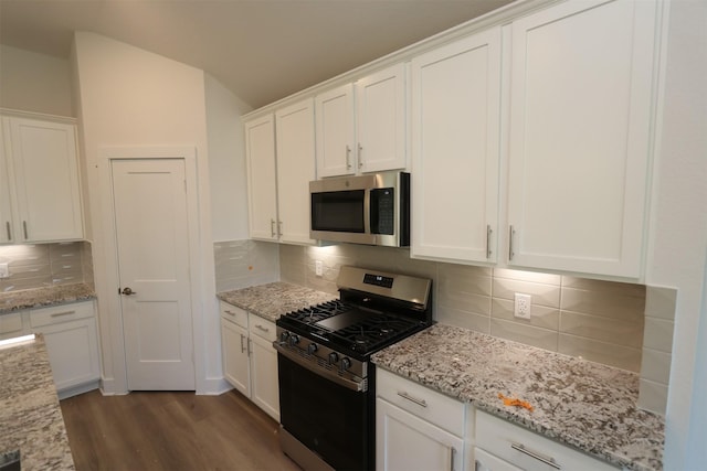 kitchen with white cabinetry, appliances with stainless steel finishes, dark wood finished floors, and backsplash