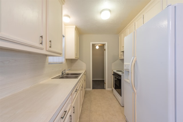 kitchen featuring light tile patterned flooring, a textured ceiling, sink, and white appliances