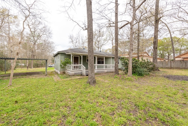 back of house featuring a yard and covered porch