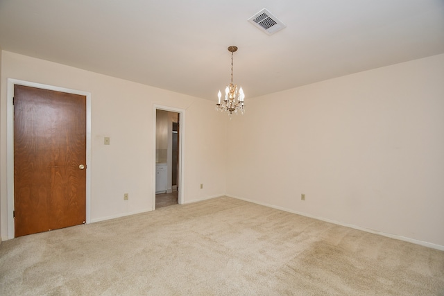 carpeted spare room with an inviting chandelier