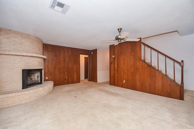 8218 Hazen St, Houston, TX 77036 - unfurnished living room with ceiling fan, carpet floors, a fireplace, stairway, and a textured ceiling
