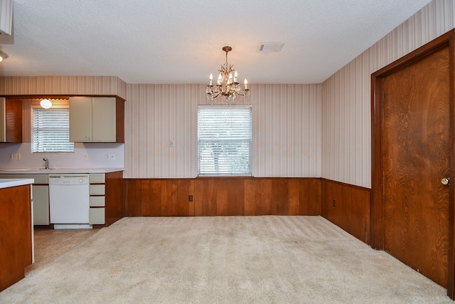 kitchen with a wealth of natural light, dishwasher, decorative light fixtures, and light colored carpet